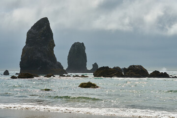 Oregon Coast Pinnacles Cannon Beach USA. Fog behind pinnacles at Cannon Beach, Oregon as the surf washes up onto the beach. United States.

