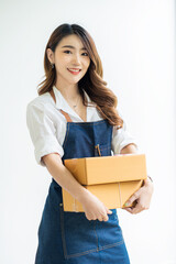 Young Asian woman holding a work-at-home box and starting a small SME business with online internet. and laptop on the table online shopping and delivery concept