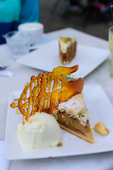 Torta de manzanas con helado servido en mesa en formato vertical