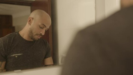 Pessimistic brown skin guy cleaning his face in the morning