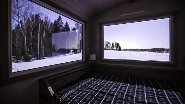 Night timelapse of starry sky over snowy field, seen through cabin bedroom windows