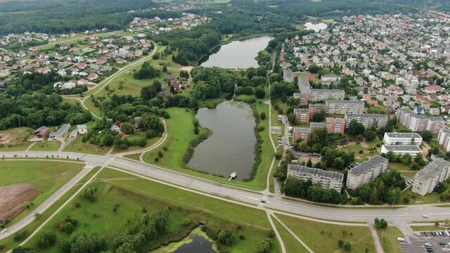 Small water ponds near big living district with private and apartment buildings of Jonava, aerial drone view
