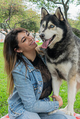 Siberian dog, black and white, playing in a park in Bogotá (Colombia) with its owner