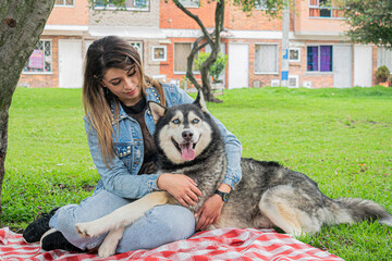 Siberian dog, black and white, playing in a park in Bogotá (Colombia) with its owner