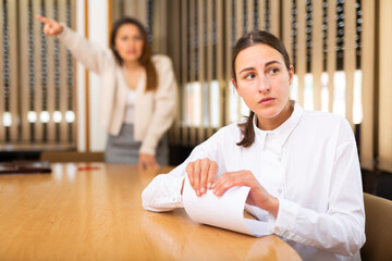 Portrait of frustrated woman holding dismissal letter at office