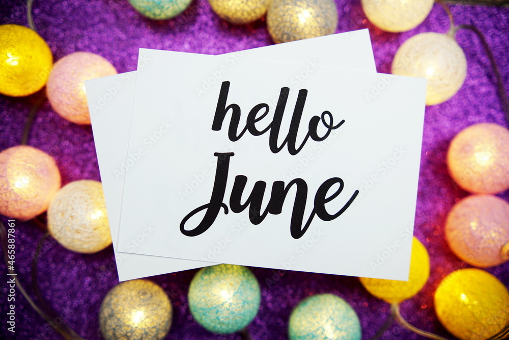 Aufkleber hello june text on paper card top view on purple bokeh background