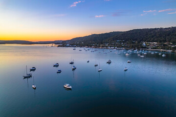 Fototapeta premium Aerial sunrise waterscape with boats and high cloud