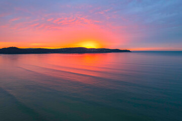 Obraz premium One hundred percent colourful cloud covered sunrise over the sea