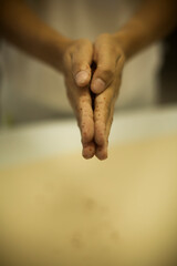 Human Hand sprinkling black pepper on pasta - making Raw and dry pasta on kitchen table -