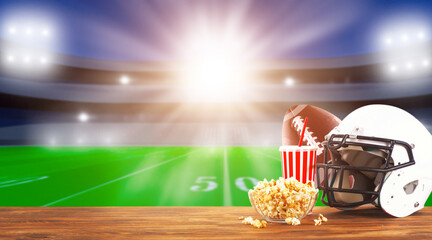 Food and drinks on a wooden table . TV broadcast of American football background. Sport bar concept