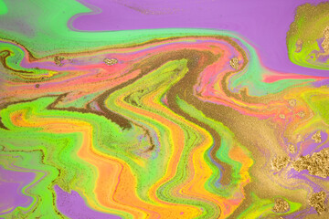 Streams of liquid purple, pink, green and gold ink curls. Waves of fluid vivid golden fluid paint.