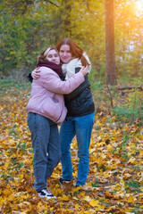 two red-haired smiling girls against the background of autumn nature, the concept of human emotions