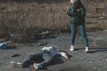 a female forensic expert photographs a dead homeless girl killed during the war on the road at a checkpoint