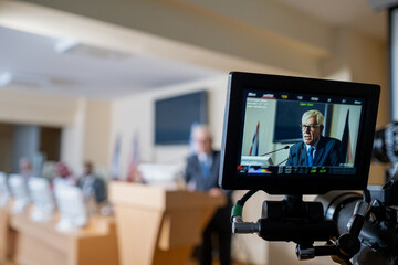 Focus on digital screen of videocamera recording political speech of senior politician speaking...