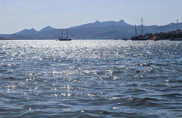 Blue sea sparkling in the sun. Beautiful coast with islands, mountains and yachts. Summer holidays concept