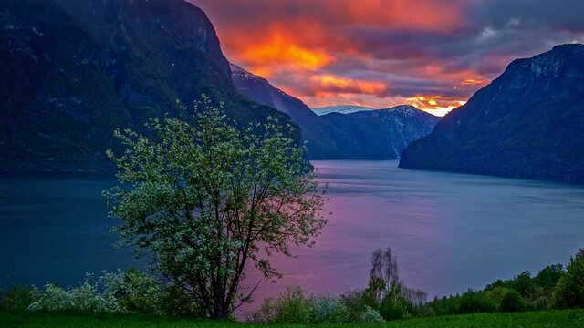 sunset timelapse behind dark clouds, over Aurland fiord in Flam village, Vestland, Norway