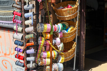 Reels of coloured ribbons on display in front of a craft store.