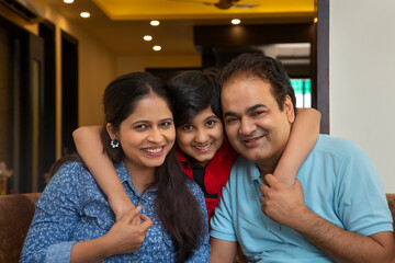 Young boy posing in front of camera with her parents