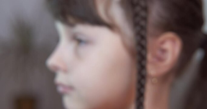 Hairstyle with pigtail. A modern child with long hair show her pigtail in the room.