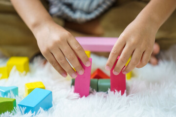 Obraz na płótnie Canvas Children play wooden blocks with geometric shapes.