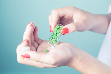 young woman holding capsules in her hand