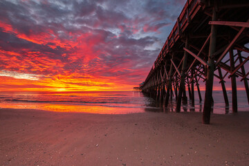 fiery sunrise at the beach pier