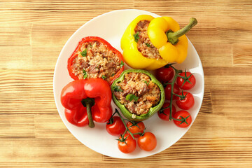 Stuffed pepper in plate on wooden background