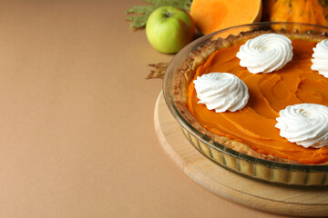 Concept of tasty food with pumpkin pie on beige background