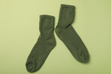 Pair of green socks on green background
