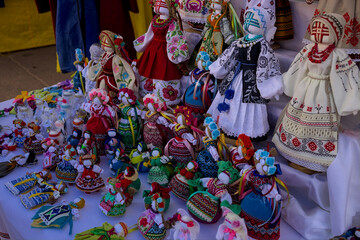 Ukraine -  An open-air traditional craft fair on a city street. Shown are handmade dolls dressed in national clothes. Different sizes and different colors.
