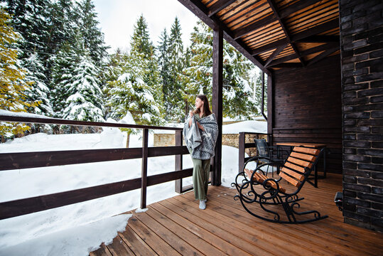 Woman enjoying view on snowy forest from terrace
