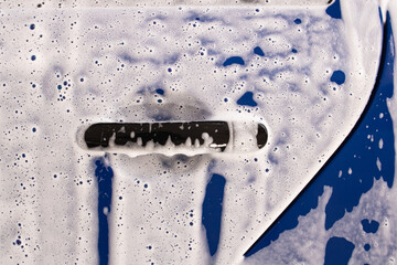 Blue car in foam at a car wash