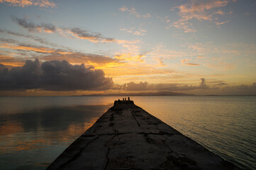 Fototapeta premium 竹富島の西桟橋から夕日を眺める人々