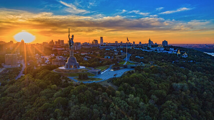 Aerial view to the Motherland statue in the Kiev while  summer sunset. The well-known landmarks in Kyiv. Historical monument of Soviet union. Beautiful city Kiev while sunset.