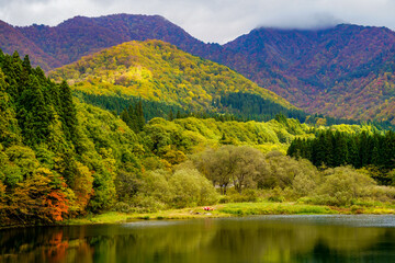 雲に頂上を覆われた秋の大源太山と大源太湖
