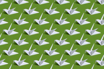 Seamless background with paper cranes. White paper birds on a plain background. Crafts from paper with children. Classic origami.