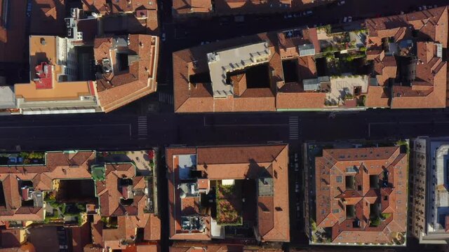 Bologna, Emilia-Romagna, Italy, October 2021. Drone in Bird's-eye view tracks east along Via Ugo Bassi towards the Sala Borsa surrounded by the Medieval city center on a sunny day.
