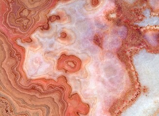 Onyx marble stone , crossed cut. Main colors are shades of red, pink and white. Texture and background. - obrazy, fototapety, plakaty