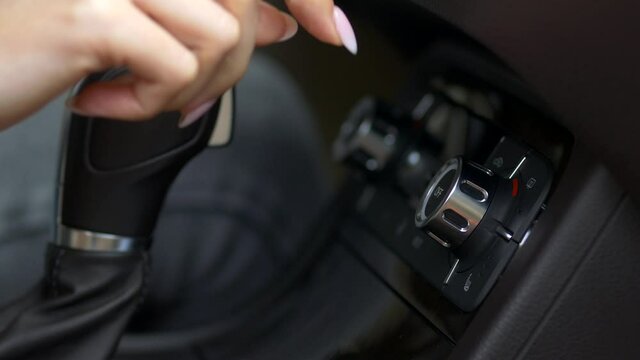 a woman's hand adjusts the air conditioner setting in the car
