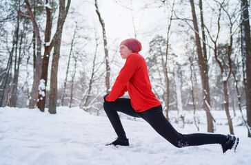 Healthy lifestyle. Young strong man is exercising at snowy park.