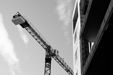 Crane and part of building against sky background. Construction site	