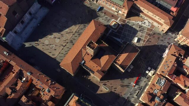 Bologna, Emilia-Romagna, Italy, October 2021. Drone in Bird's-eye view slowly orbits the Palazzo Re Enzo from the east, surrounded by the Medieval city center on a sunny day.