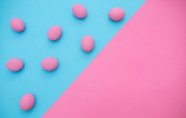 Easter concept. Creative graphic eggs on blue and pink pastel background. Place for text. Eggs in Proton Purple neon light. Background with Easter eggs.
