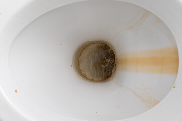 close-up dirty toilet bowl, traces of limescale and rust