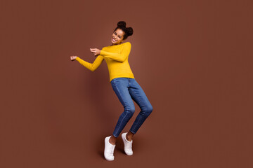 Fototapeta na wymiar Full size photo of little girl dance wear pullover jeans footwear isolated on brown color background