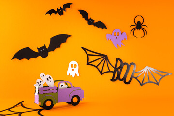 Happy halloween holiday concept. Halloween handmade paper decorations, spiders, ghosts in car, bats, boo text on orange background. Halloween festival party, greeting card mockup with copy space.