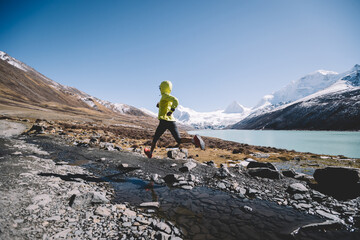 Woman trail runner running in winter mountains