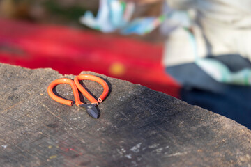 Beautiful metal scissors with a red handle on the table