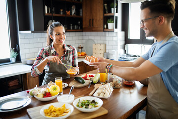 Happy people, couple cooking food together in their loft kitchen at home