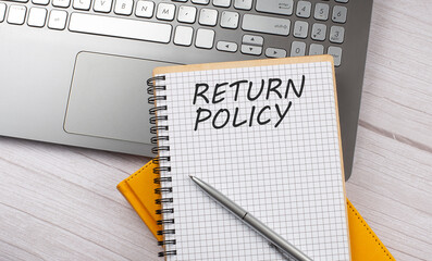 RETURN POLICY text written on a notebook on the laptop,business